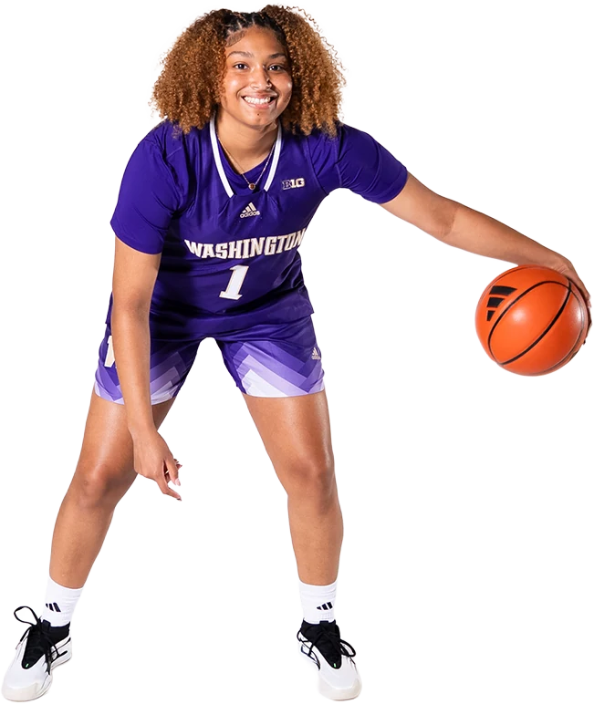 Amayah Garcia smiling in her purple Washington number 1 jersey, dribbling a basketball in a low, wide stance.