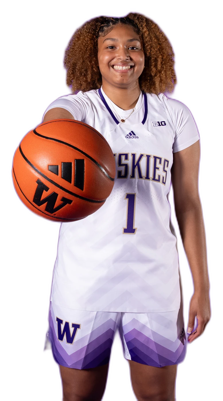 Amayah Garcia smiling in her white Washington Huskies number 1 jersey, holding a basketball out toward the camera.