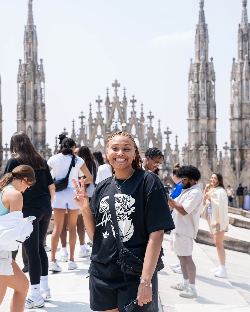 Amayah Garcia smiling and throwing a peace sign on the rooftop of the Milan Duomo in Italy.