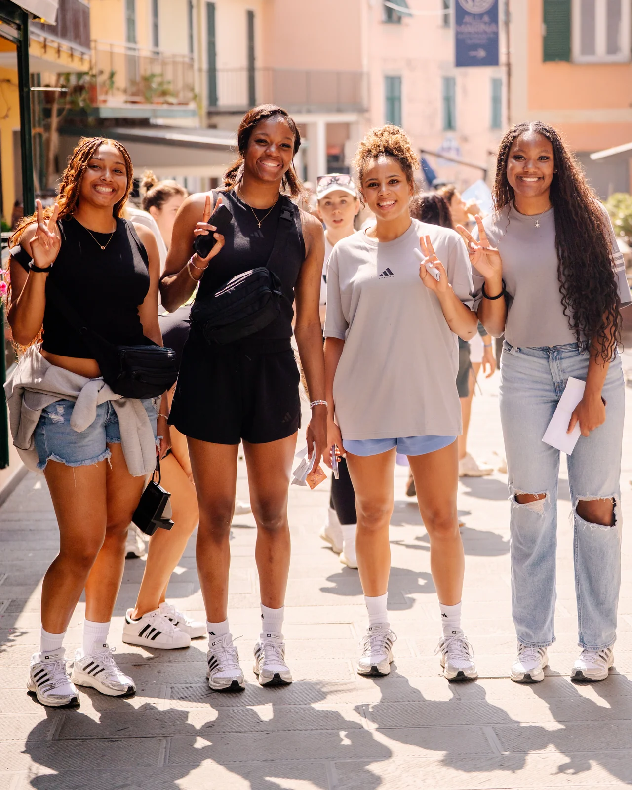 Amayah Garcia walking a sunlit Italian street with three teammates during the Adidas Eurocamp.