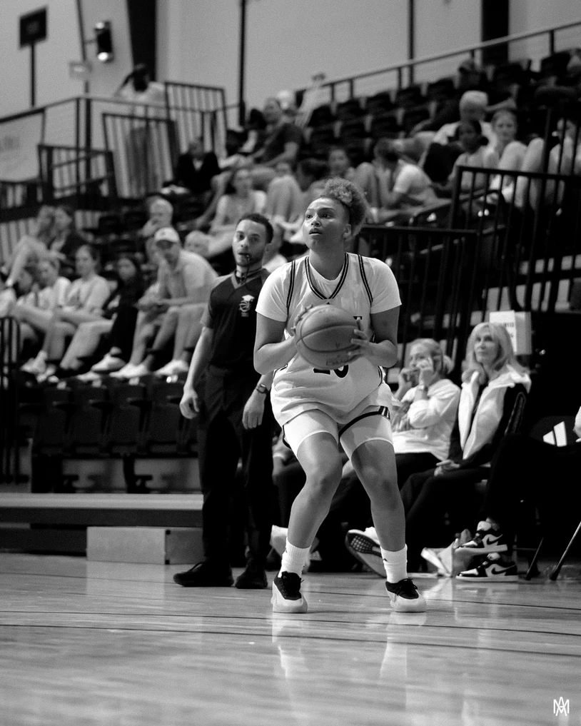 Black and white photo of Amayah Garcia squaring up to shoot with a full crowd behind her.